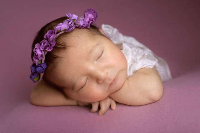 Sleeping newborn baby girl in pink